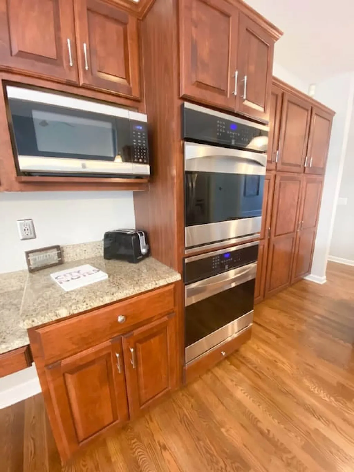 A warm, welcoming kitchen featuring stainless steel appliances, granite countertops, and rich wood cabinetry. The spacious layout is perfect for multiple cooks, and the modern appliances are ideal for preparing group meals or festive feasts.