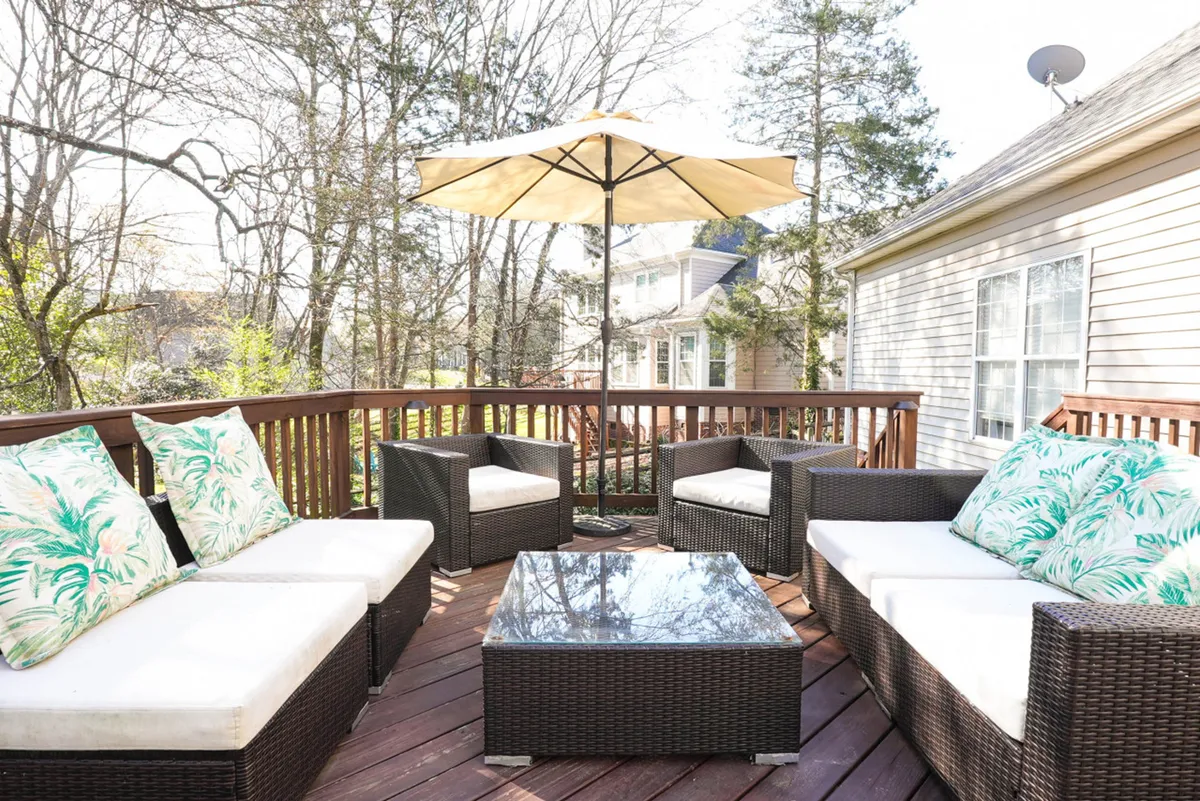 An inviting outdoor seating area, complete with comfy chairs, an umbrella, and a coffee table, offers a relaxing spot for informal meetings, breaks, or evening gatherings. The tranquil atmosphere hints at the blend of work and relaxation possible during a retreat.