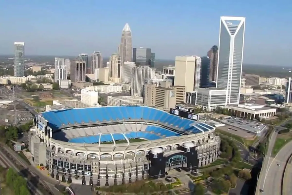 A striking cityscape view of the Charlotte skyline with Bank of America Stadium in the foreground and lush green spaces nearby. The image captures the energy and excitement of Charlotte’s downtown attractions.